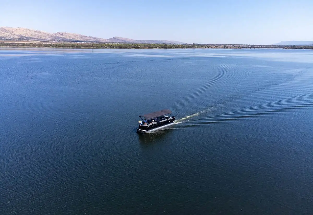 A private pontoon cruising the dam
